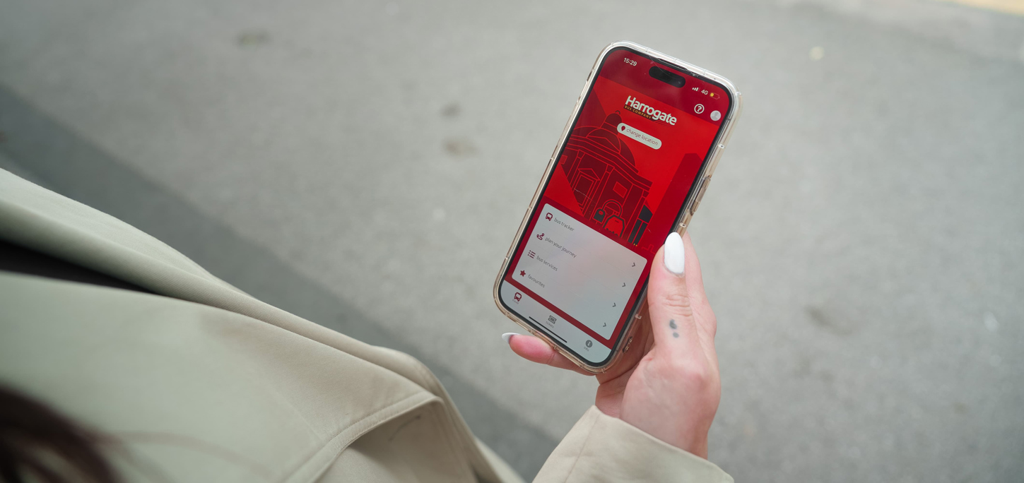 Photo of someone holding a phone with the Transdev app open